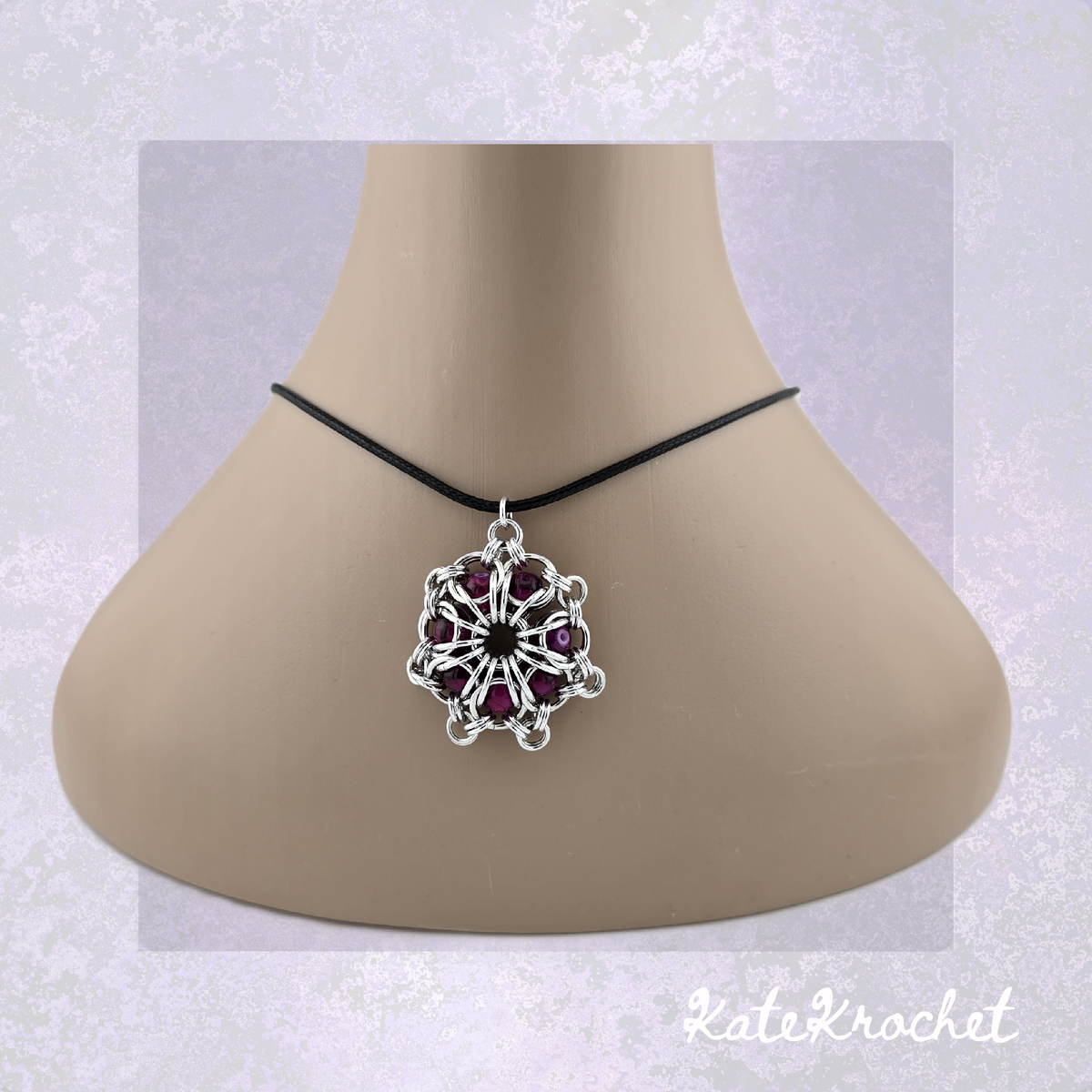 A Chainmaille captured glass bead flower pendant necklace with Crimson glass beads, displayed on a beige mannequin bust by KateKrochet.