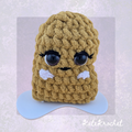 Close-up of handmade Girl Emotional Support Nugget with eyelashes and blush cheeks by KateKrochet